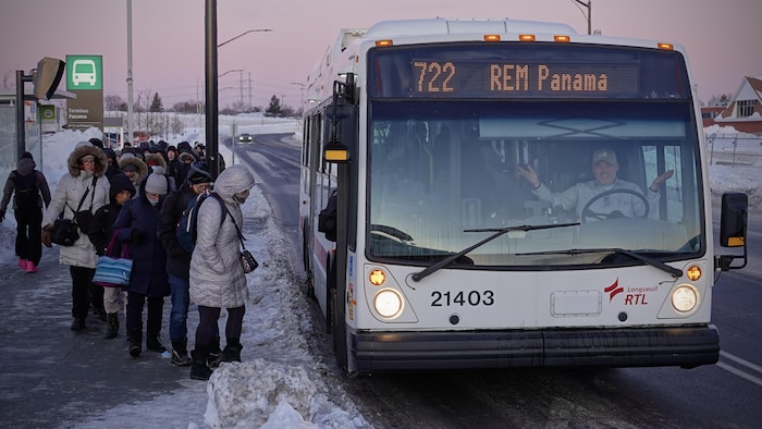 Des gens entrent dans un autobus.