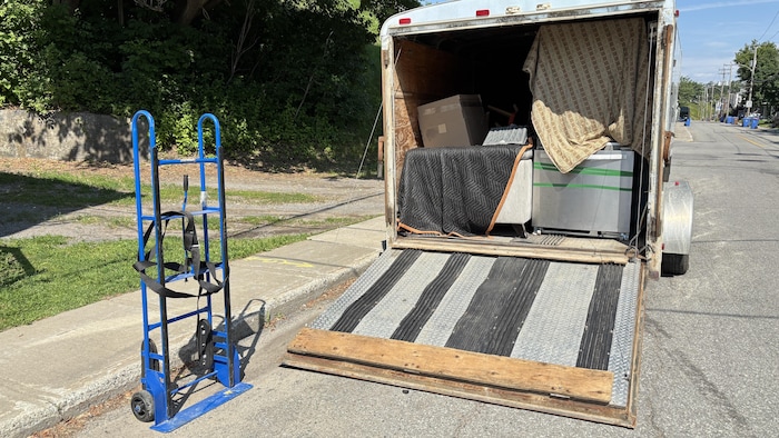 Une remorque de déménagement avec des électroménagers et un sofa.