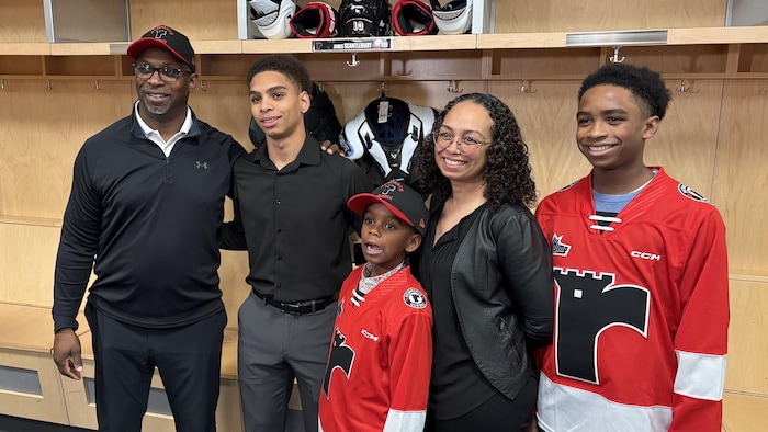 Photo de famille devant son nouveau casier dans le vestiaire des Remparts,