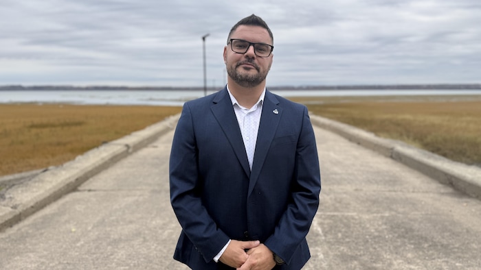 Renaud Labrecque, debout sur un quai sur le fleuve à marée basse.