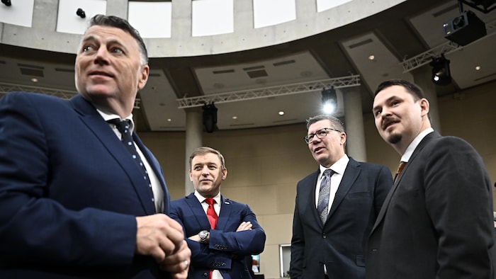 Quatre premiers ministres provinciaux parlent ensemble avant une réunion à Ottawa.