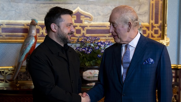 Volodymyr Zelensky et le roi Charles III se serrent la main.