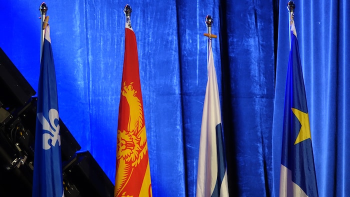 Quatre drapeaux du Québec et des provinces maritimes.