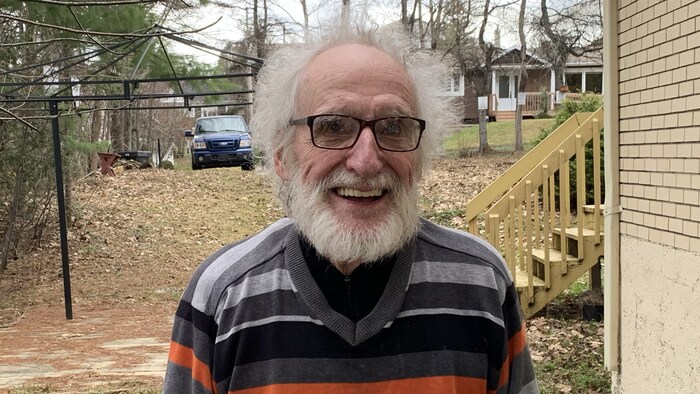 L'ancien député de Bloc Québécois, René Canuel, tout souriant, près de sa maison.