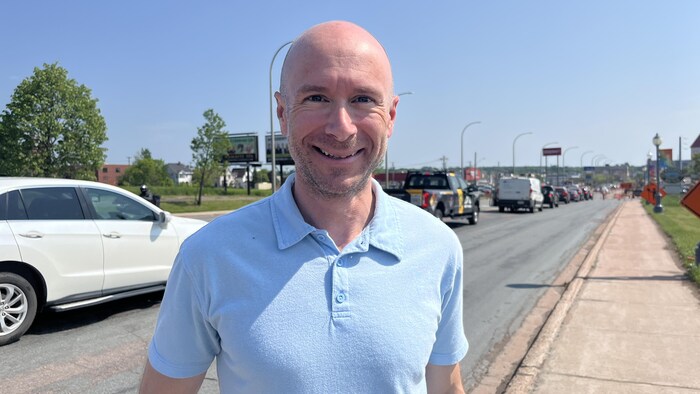 René Lagacé devant une longue file de voitures dans la rue.