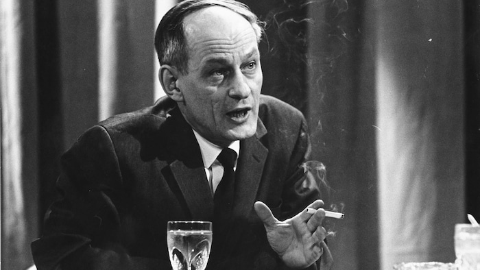 Le politicien René Lévesque, cigarette à la main, en entrevue sur un plateau d'émission.