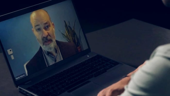 Une homme parle par visioconférence sur un écran d'ordinateur.