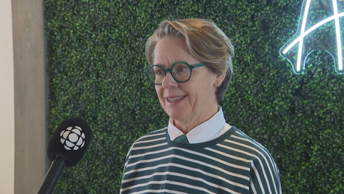 Une femme en entrevue sourit.