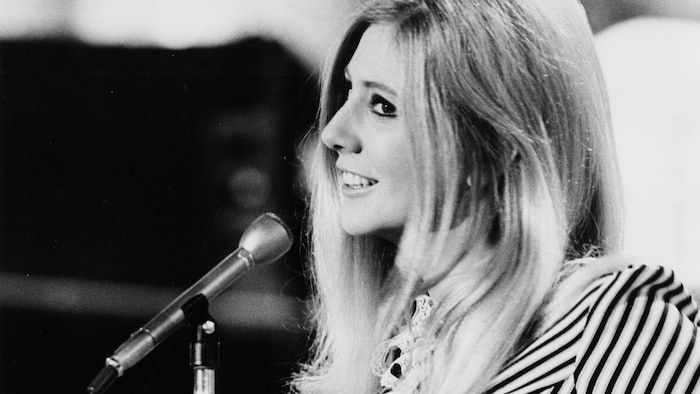 Renée Martel chante dans un micro.