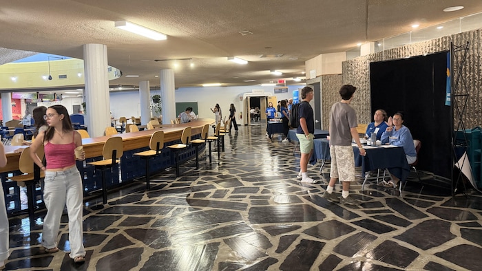 Des étudiants sont guidés par deux membres du personnel au Cégep de Jonquière.