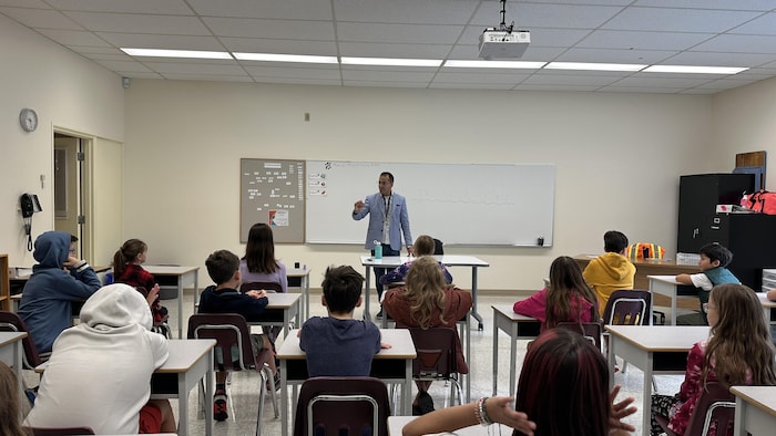 Enfants dans une classe, en train d'écouter leur enseignant. 