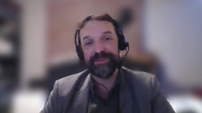 un homme regarde la caméra.