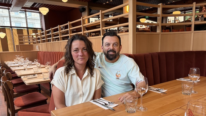 Deux personnes assises sur une banquette.