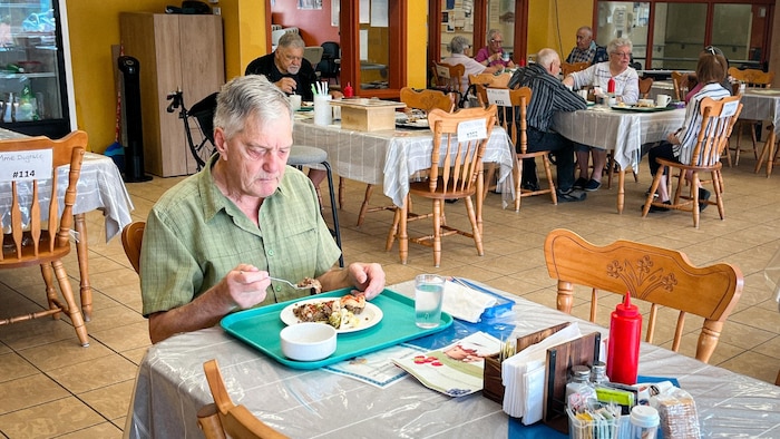Un aîné mange son diner dans la cantine de la résidence Vents et Marées de Sept-Îles.