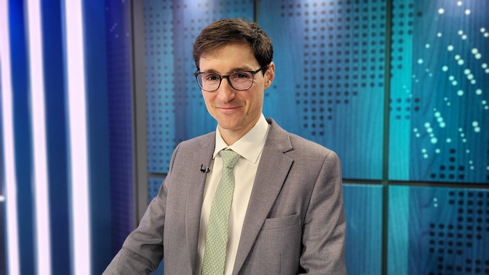 Un homme pose dans un studio de télévision.