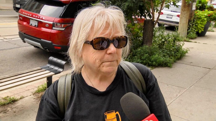 Lori Gibson répond aux questions d’une journaliste dans une rue.