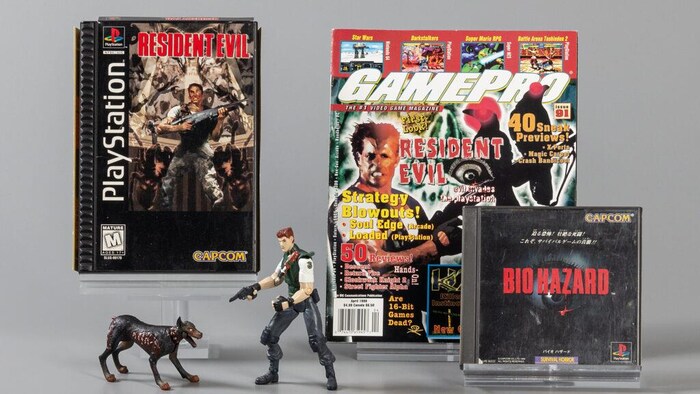 Un magazine, des figurines et deux pochettes de jeux vidéo de Resident Evil sur une table. 