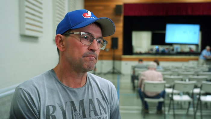 Normand Duval se trouve dans une salle de conférence.