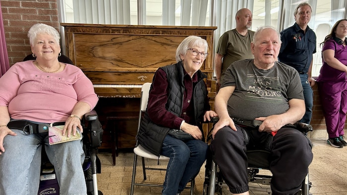 Des personnes âgées assises, souriantes.