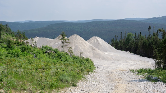 Monticule de poudre blanche devant une paysage montagneux.