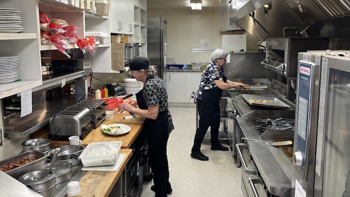 Deux cuisinières font à manger au restaurant de Cadillac.