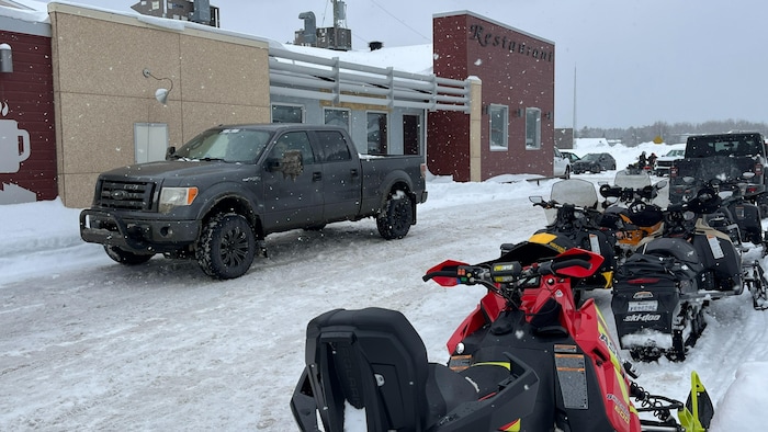 Des motoneiges sont stationnées devant un restaurant du quartier Cadillac.