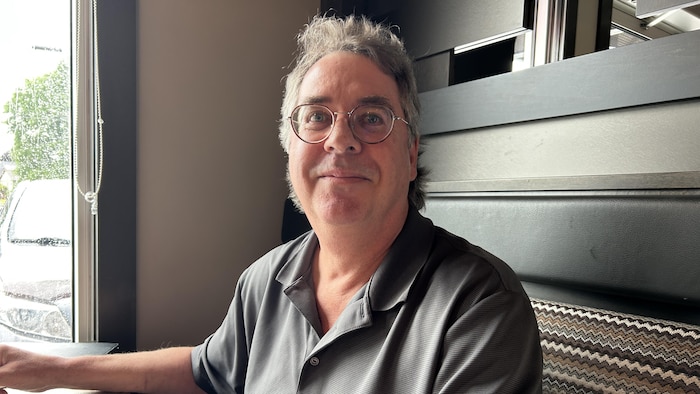 Un homme interviewé à une table d'un restaurant.