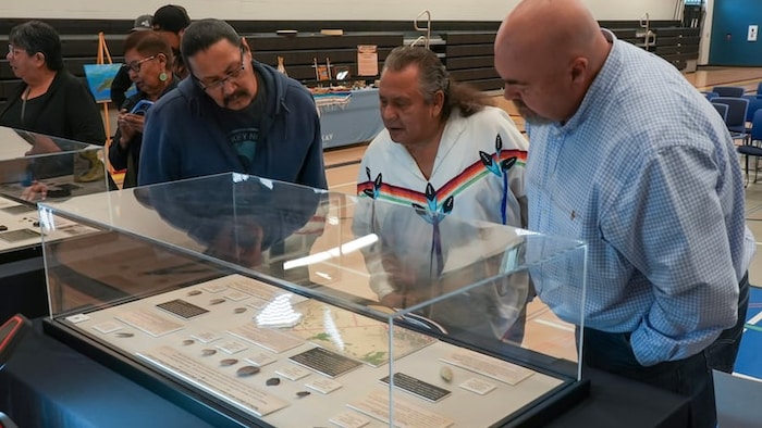 Des personnes examinent des objets restitués à la Première Nation de Fort McKay par le Musée royal de l'Alberta lors d'une cérémonie organisée à l'école Elsie Fabian le 31 juillet 2026.
