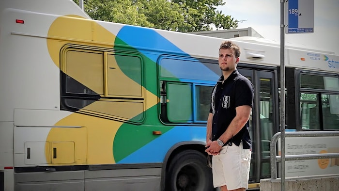 Un jeune homme attend le bus au terminus Honoré-Beaugrand à Montréal