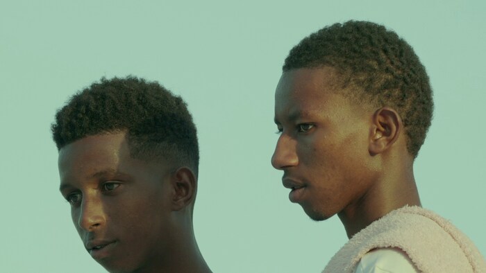 Une photo de deux hommes noirs du film Murmures, du réalisateur rwandais Kivu Ruhorahoza.