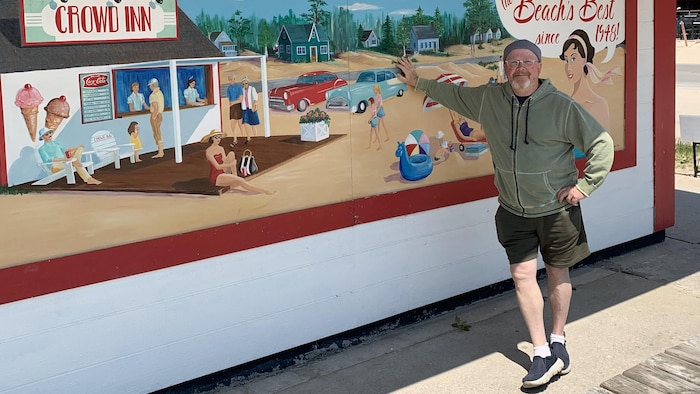 Un restaurateur qui s'appuie sur la murale de sa friterie.