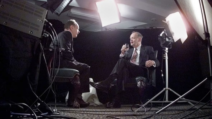 Rex Murphy, left, chats with then-prime minster Jean Chrétien, ahead of an interview, in November 2000. Murphy has died at age 77, the National Post reported on Thursday.