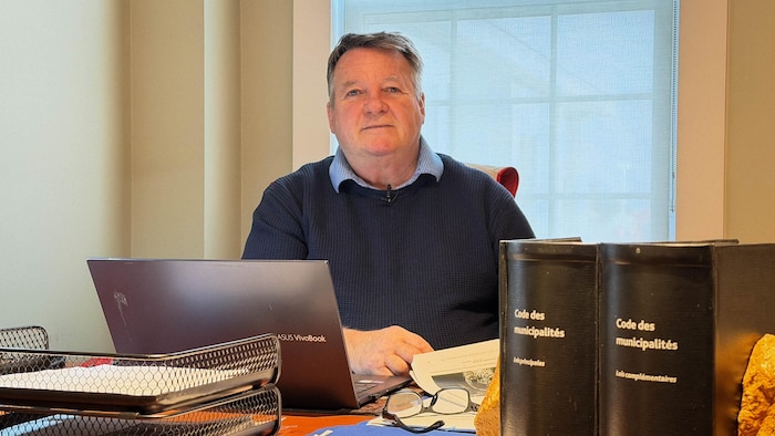 Un homme assis à un bureau.