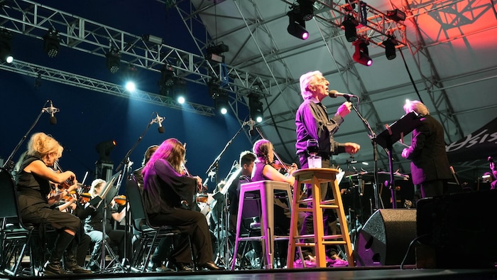 Richard Desjardins et l'Orchestre symphonique régional sur la scène d'Osisko en lumière.
