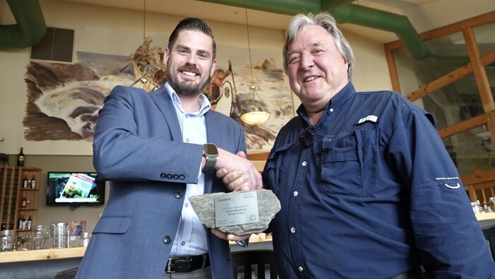 Un homme remet une plaque honorifique à Richard Lafleur.