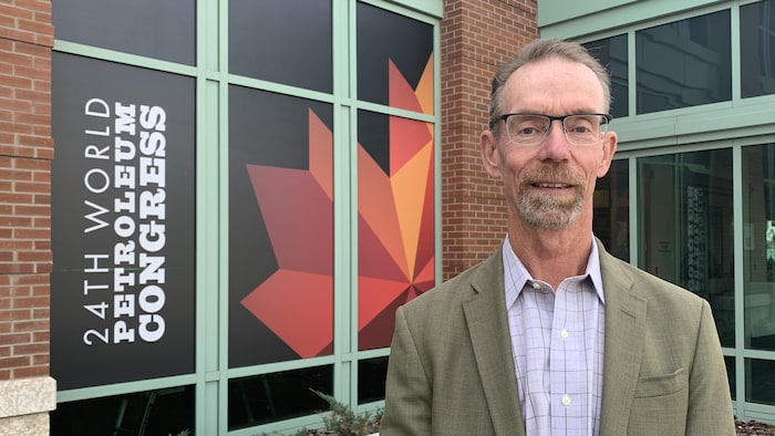 Richard Masson devant une enseigne du 24e Congrès mondial du pétrole.