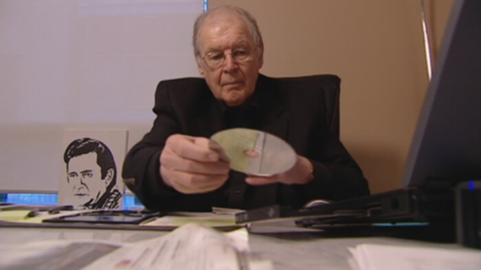 Richard Nemis glisse un CD dans un ordinateur portable.
