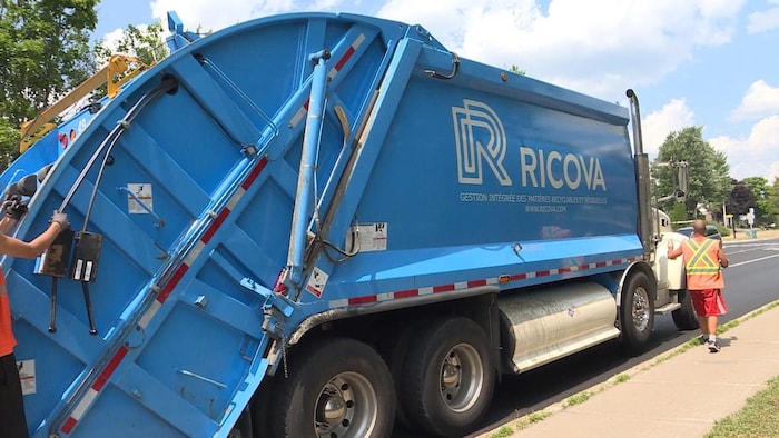 Un camion à ordures bleu.