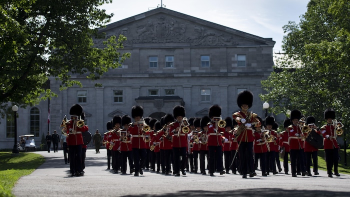 Miembros de la Guardia Ceremonial desfilan frente a Rideau Hall, la residencia oficial del Gobernador o de la Gobernadora General de Canadá. 
