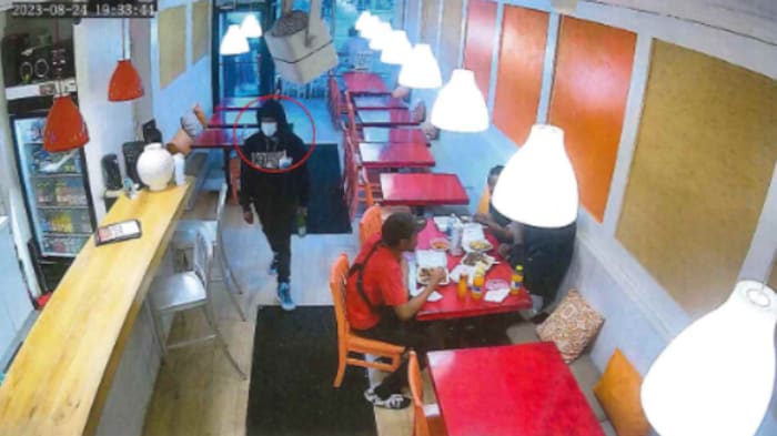 Un homme muni d’un masque sanitaire entre dans un restaurant.