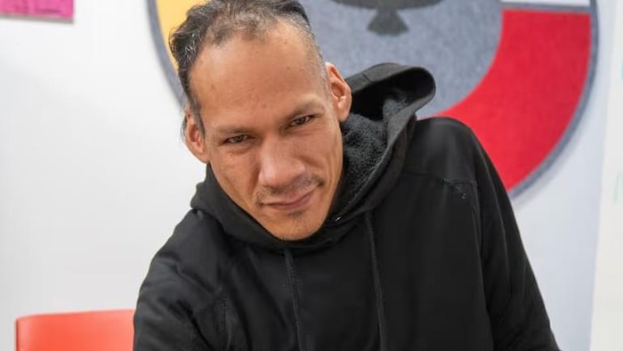 Riel Lyon pose devant la photo.