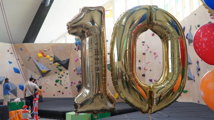 Des gros ballons en forme de 10 dans un centre d'escalade.