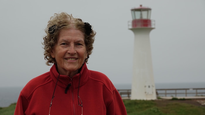 Rita Arsenault devant un phare.