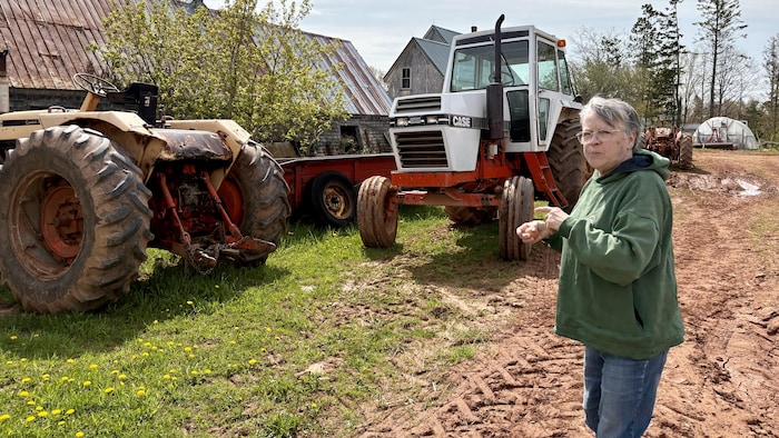 Rita Jackson est à côté de ses tracteurs. 