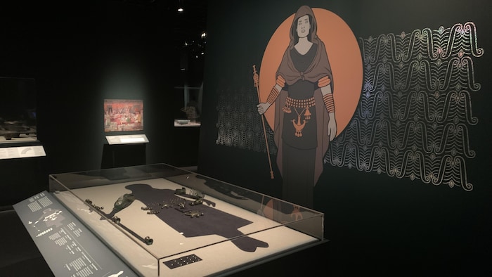 Des objets antiques présentés dans des vitrines et un dessin représentant l'âge du fer sont présentés dans un musée.
