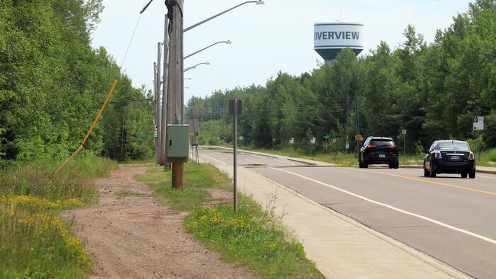 Un sentier de terre de Riverview et une route avec deus voiture, juste à côté.