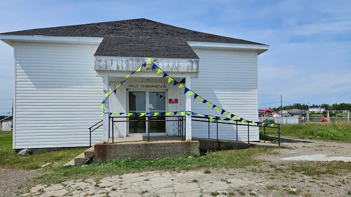 L'entrée de la salle communautaire de la municipalité, drapée de guirlandes de fanions bleus et jaunes.