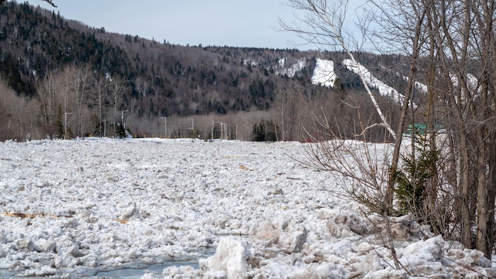 La rivière plein de glace au pied des pentes de ski.