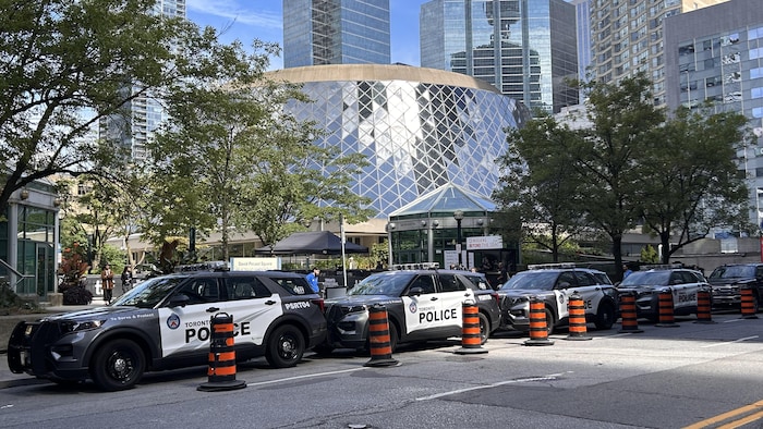 Quatre autopatrouilles protégées par des cônes sur la rue Wellington à côté du Roy Thompson Hall.