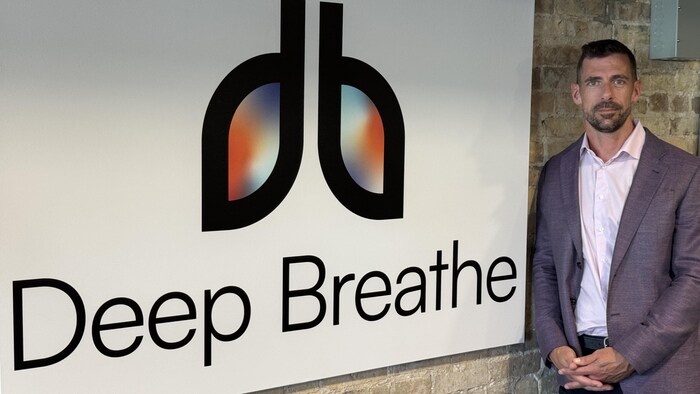 Le docteur Rob Arntfield devant le logo de Deep Breathe.